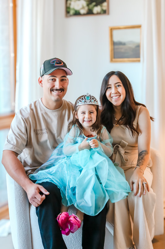 Family with young daughter in a blue dress