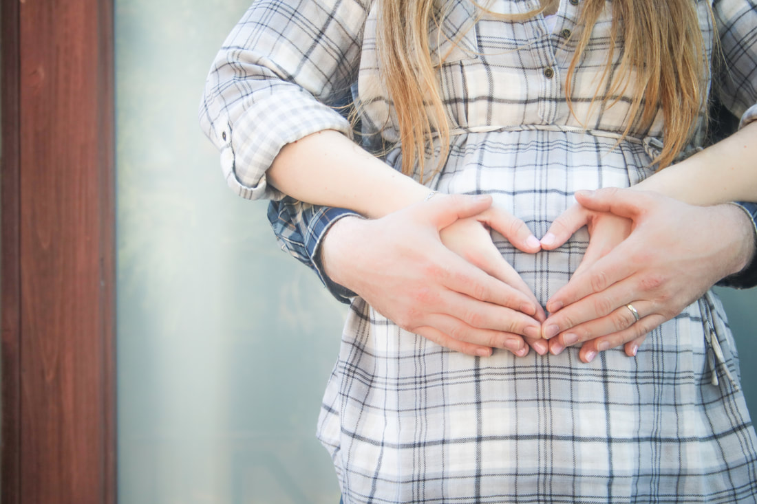 Expecting parents, hands in a heart